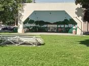 A Large bandshell with colorful mural painted in the shell area.