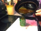 Picture of pouring oil from a pan into a can